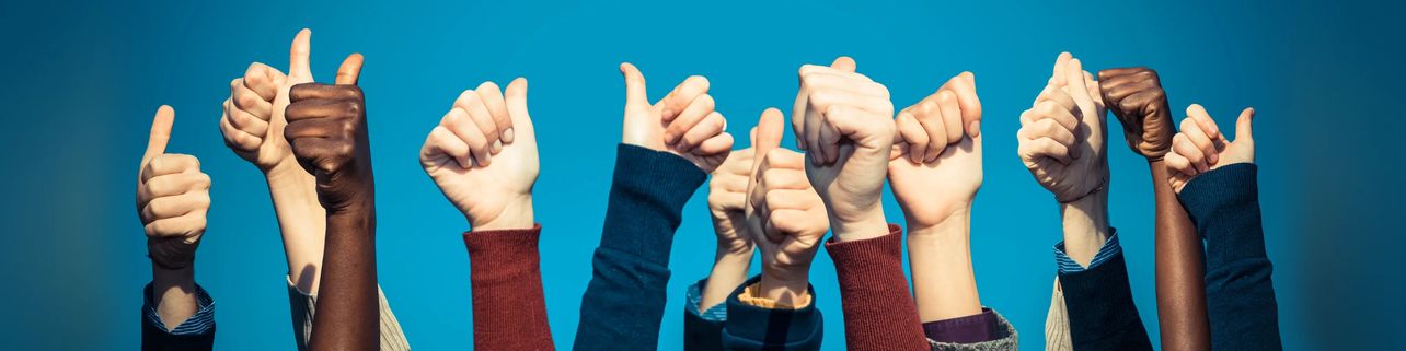 Diverse group of people with their arms raised up giving a thumbs up signal.