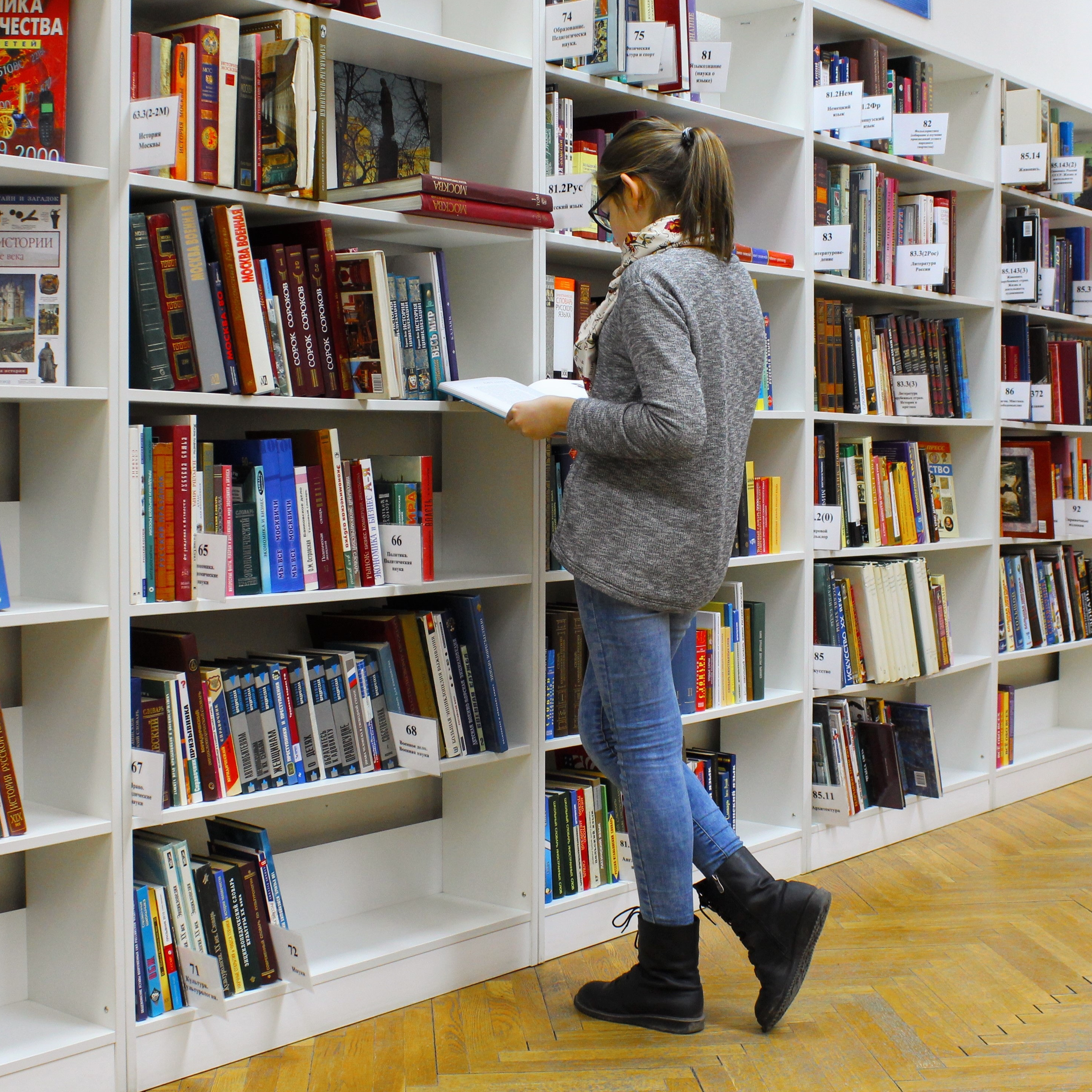 A woman reading a book at a library